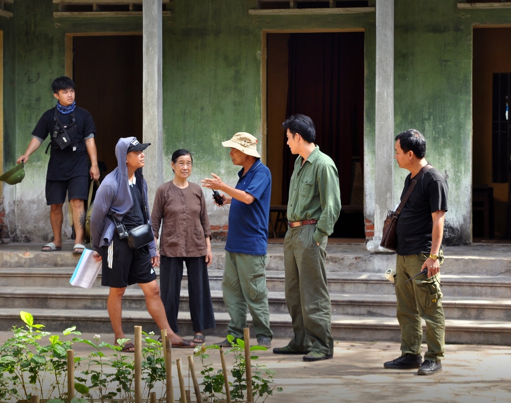 Đạo diễn Lưu Trọng Ninh trao đổi với diễn viên và các thành viên trong đoàn về một phân đoạn trong phim.