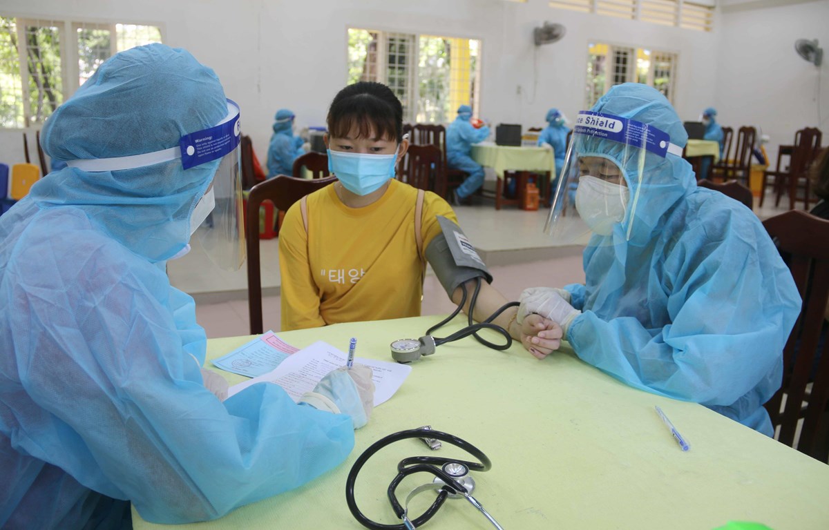Khám sàng lọc trước khi tiêm vaccine tại điểm tiêm trường Đại học Trà Vinh. (Ảnh: Thanh Hòa/TTXVN)