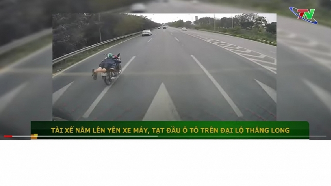 Nam thanh niên nằm trên yên xe máy, tạt đầu ô tô trên đại lộ Thăng Long